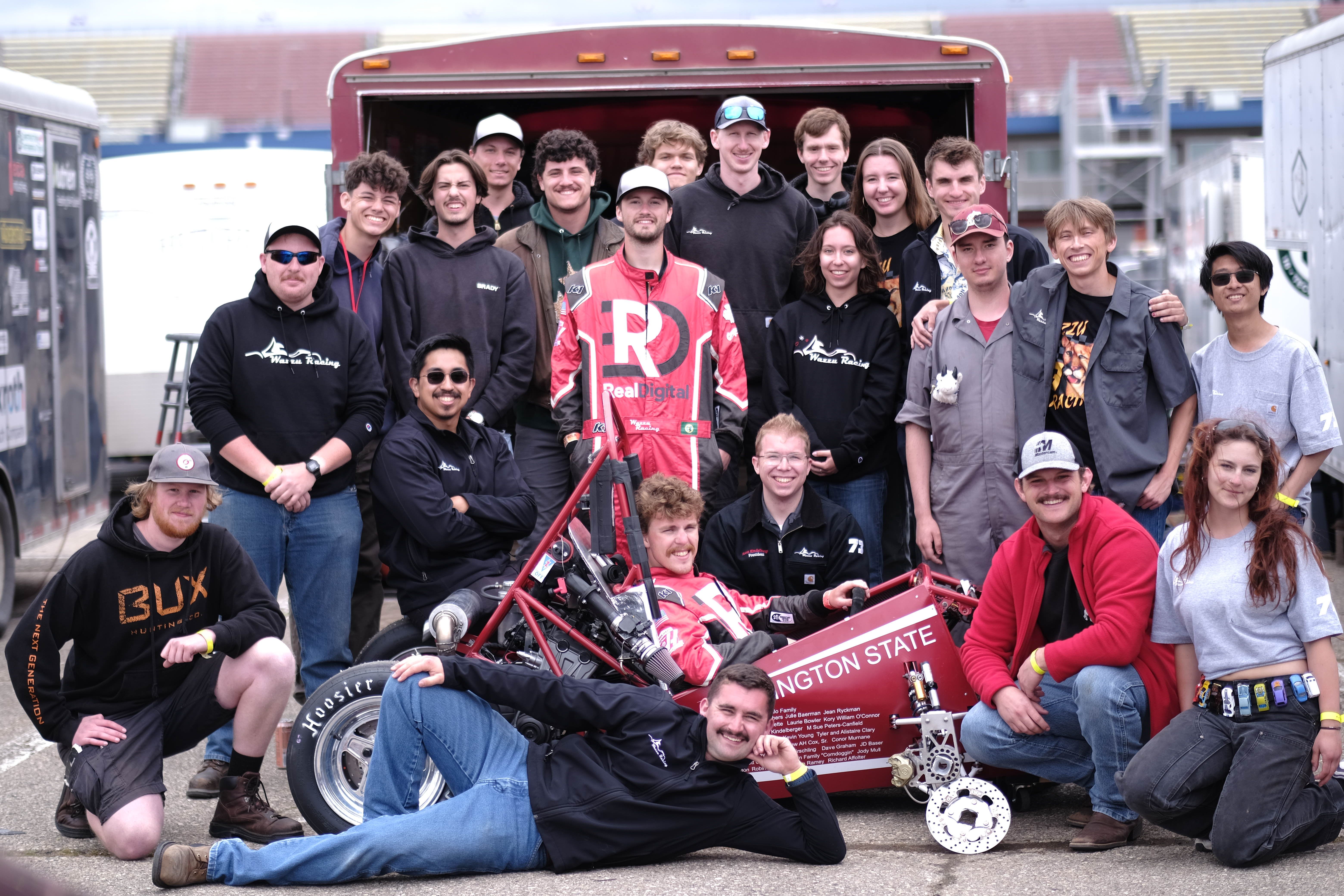 Wazzu Racing team posing in front of the car